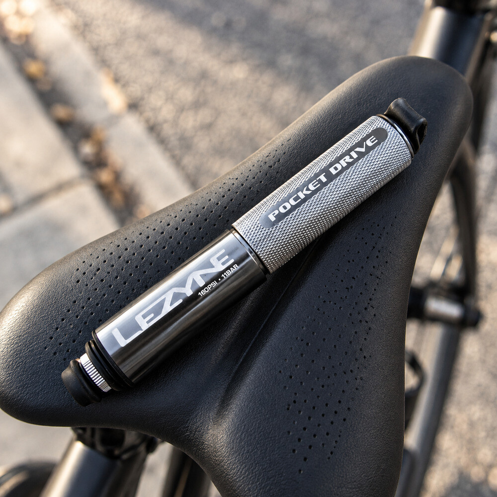 Mini bomba Lezyne Pocket Drive prata apoiada no selim de uma bicicleta de estrada